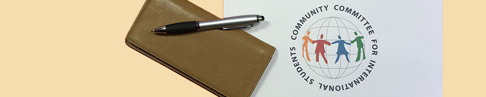 Writing pen resting on a checkbook.