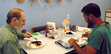 Male homestay host and male international eating American pancakes.