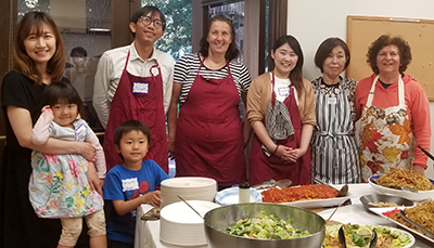 Participants and volunteer are happy and smiling after preparing a tableful of delicious food