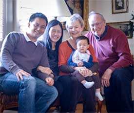 Member couple at home hosting an international couple and their baby